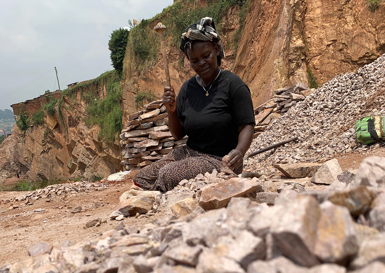 Ugandan woman breaking stones in a quarry with a makeshift hammer