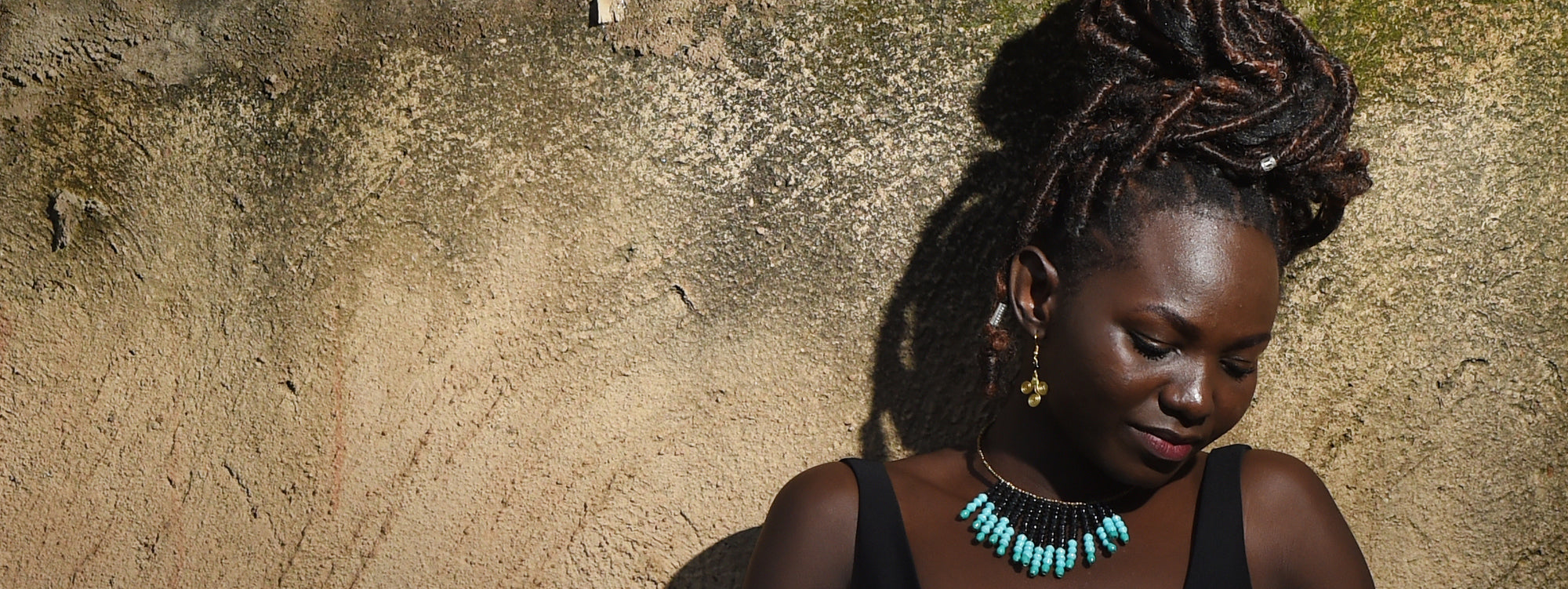 African woman modeling fair trade jewelry made from recycled paper