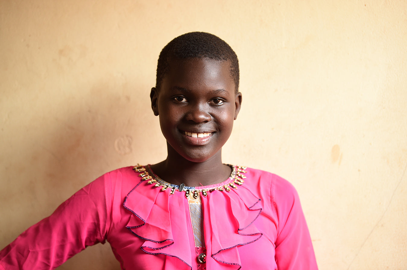 Smiling Ugandan girl with pink blouse