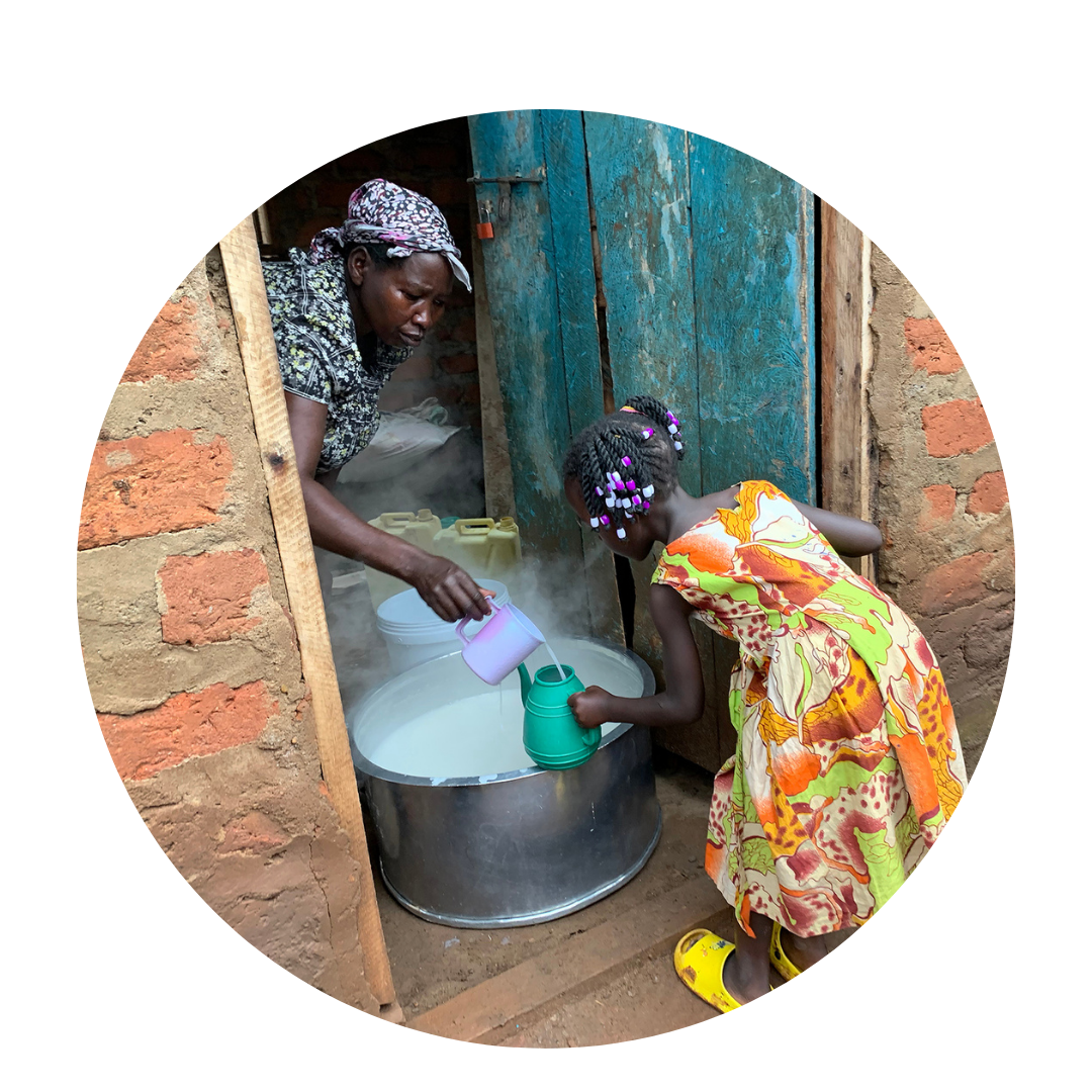 Ugandan woman serving a child breakfast